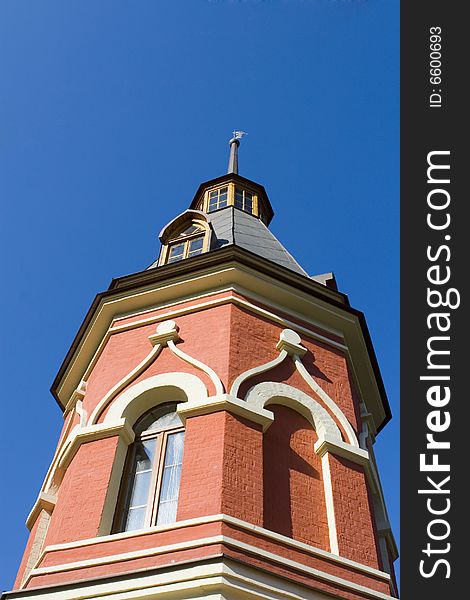 Old red tower on blue ground