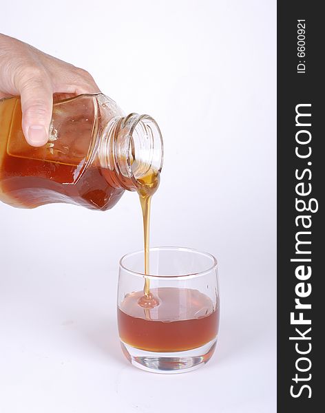 Pouring honey  on white background