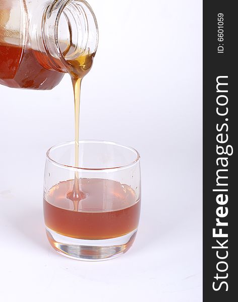 Pouring honey  on white background