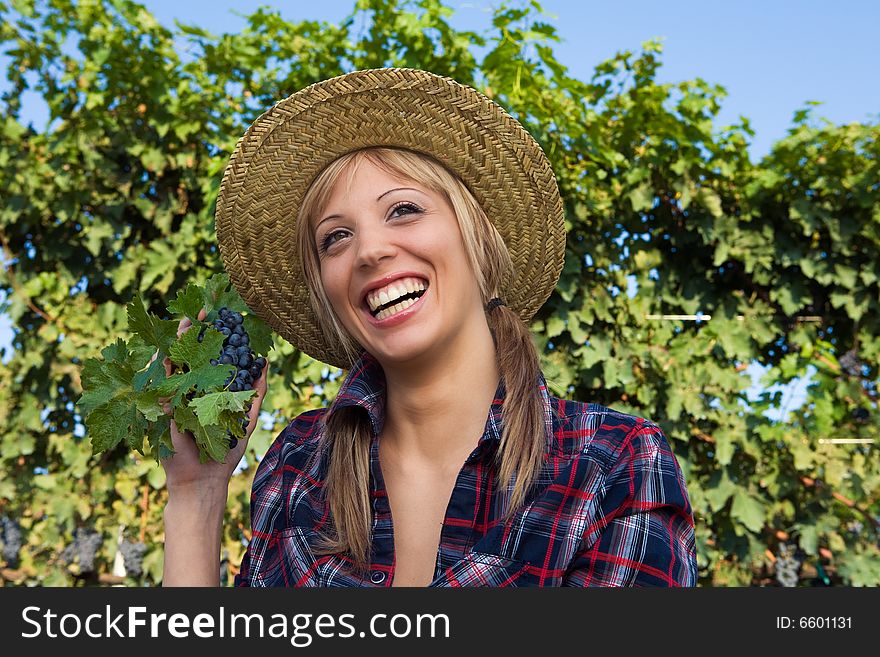 Closeup portrait of a happy young peasant woman among the vineyards