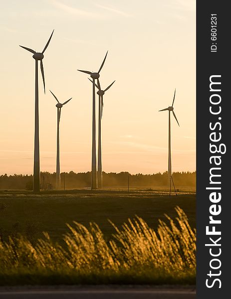 Wind farm turbines generators rows at dusk. Wind farm turbines generators rows at dusk