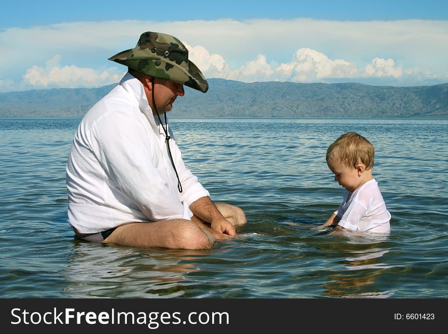 Father and small son play on the water. Father and small son play on the water