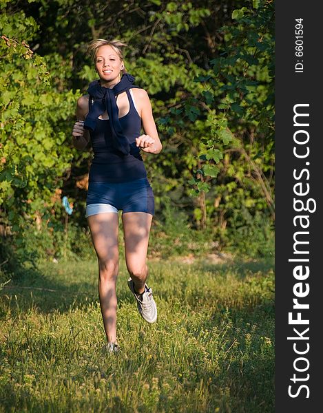 Young and athletic blond woman, running between the vineyards in a beautiful summer day. Young and athletic blond woman, running between the vineyards in a beautiful summer day.