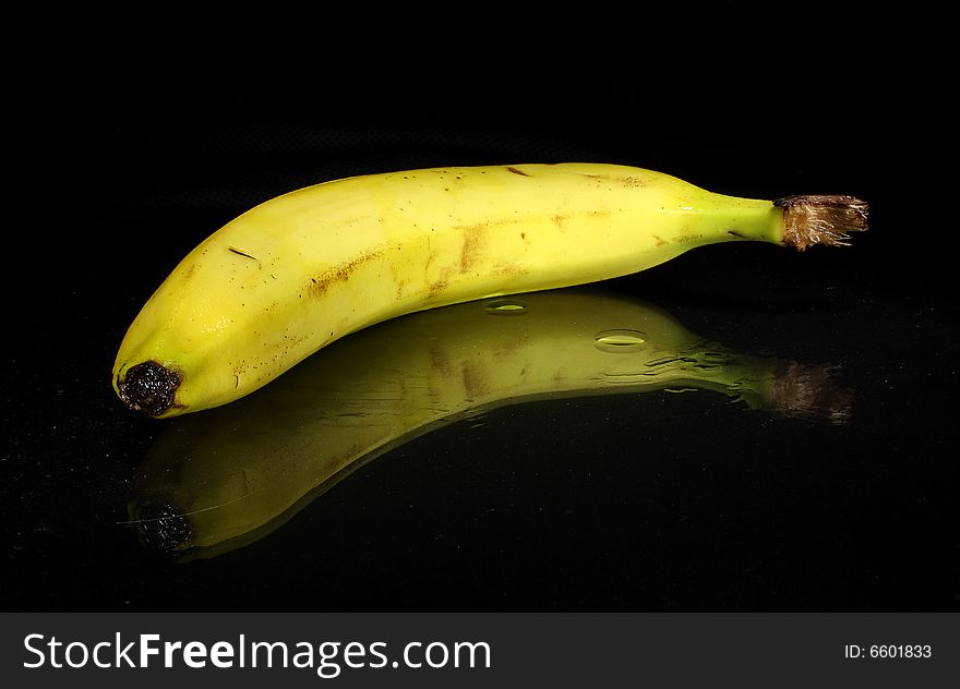 A yellow banana on a dark background