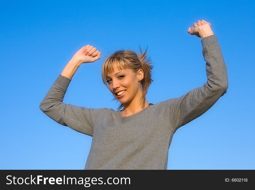 Young Woman Spreading Arms To  Blue Sky