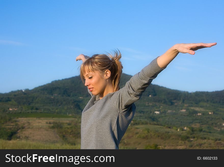 Young Woman Spreading Arms To  Blue Sky