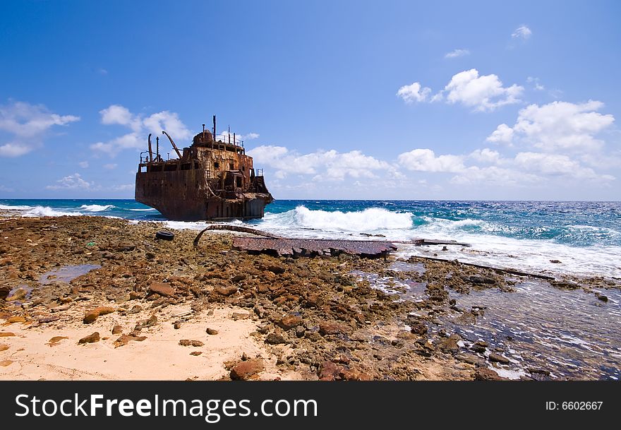 Rusty caribbean shipwreck washing ashore