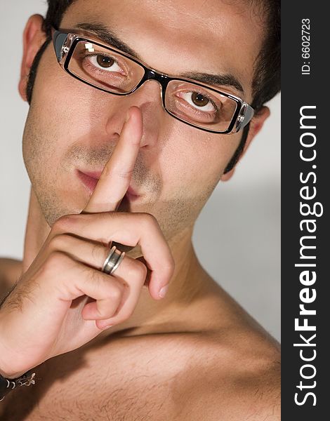 Expression of a man of the concept of silence / Shut up with his finger in front of his mouth and nose / Glasses and ring / Soft lights to amplify this idea. Expression of a man of the concept of silence / Shut up with his finger in front of his mouth and nose / Glasses and ring / Soft lights to amplify this idea