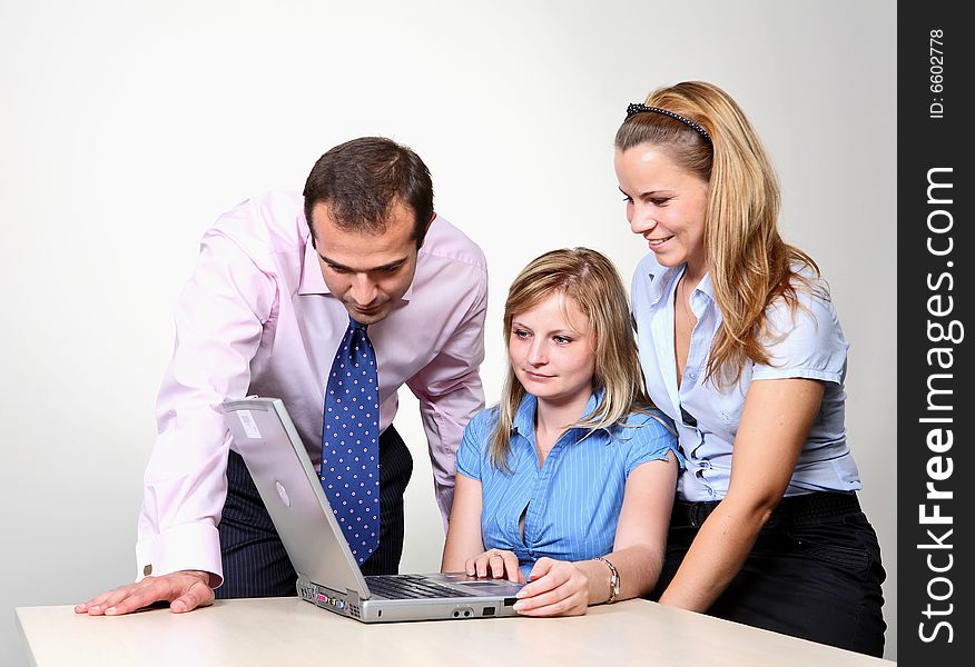 Three colleagues working at a computer