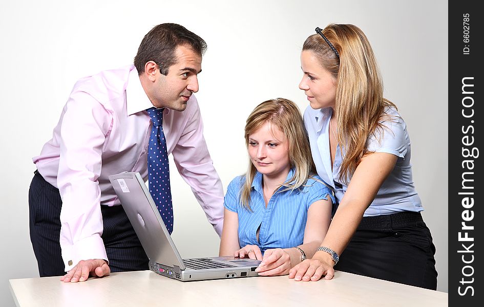 Three colleagues working at a computer: a man received consultation from his female colleagues