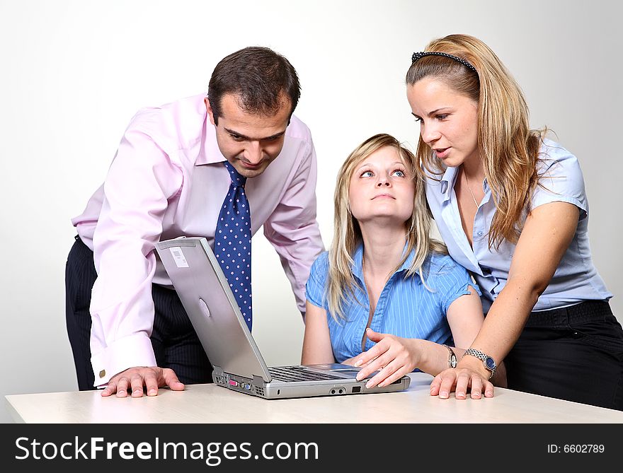 Three colleagues working at a computer