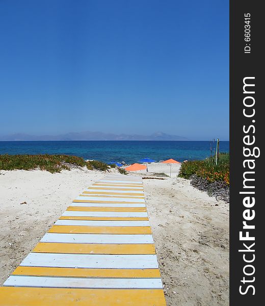 Beach under a blue sky with path