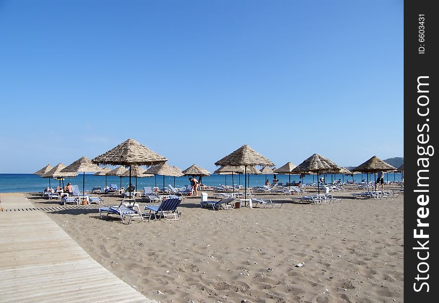 Beach under a blue sky with umbrellas