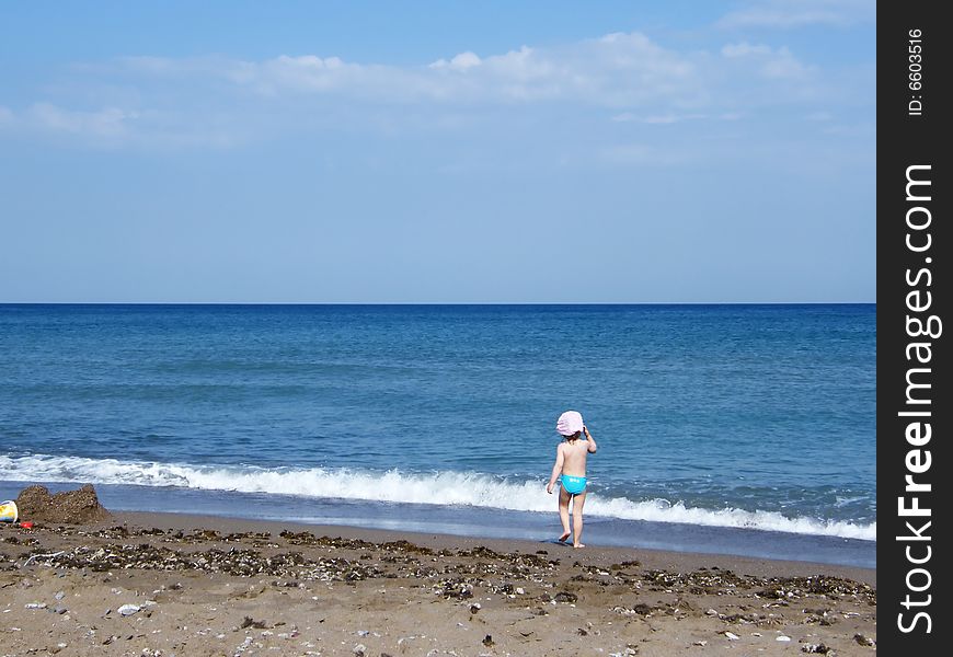 Beach under a blue sky with child