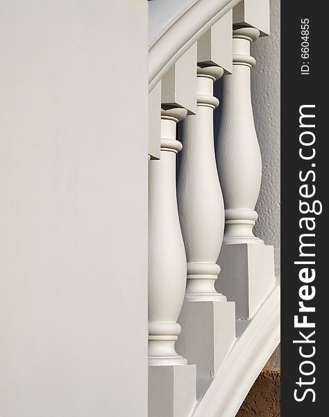 White, large, columns on a banister with negative space on the left. White, large, columns on a banister with negative space on the left.