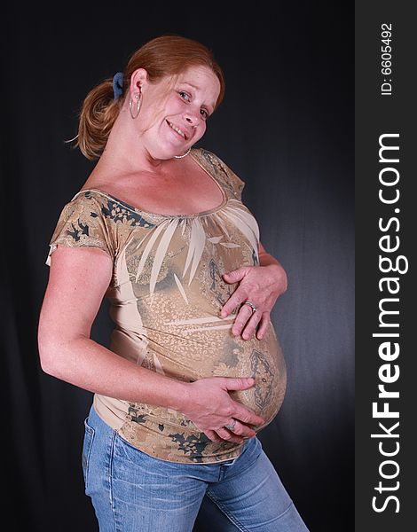 Very happy mommy with her hands on her pregant belly. Very happy mommy with her hands on her pregant belly