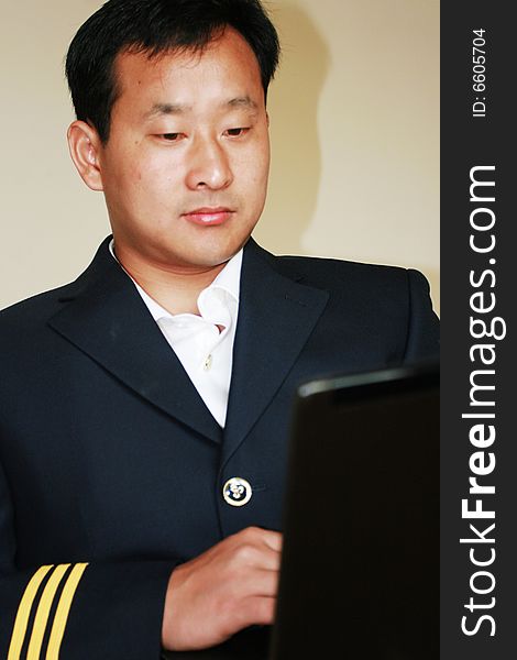 A young pilot using a laptop  at home