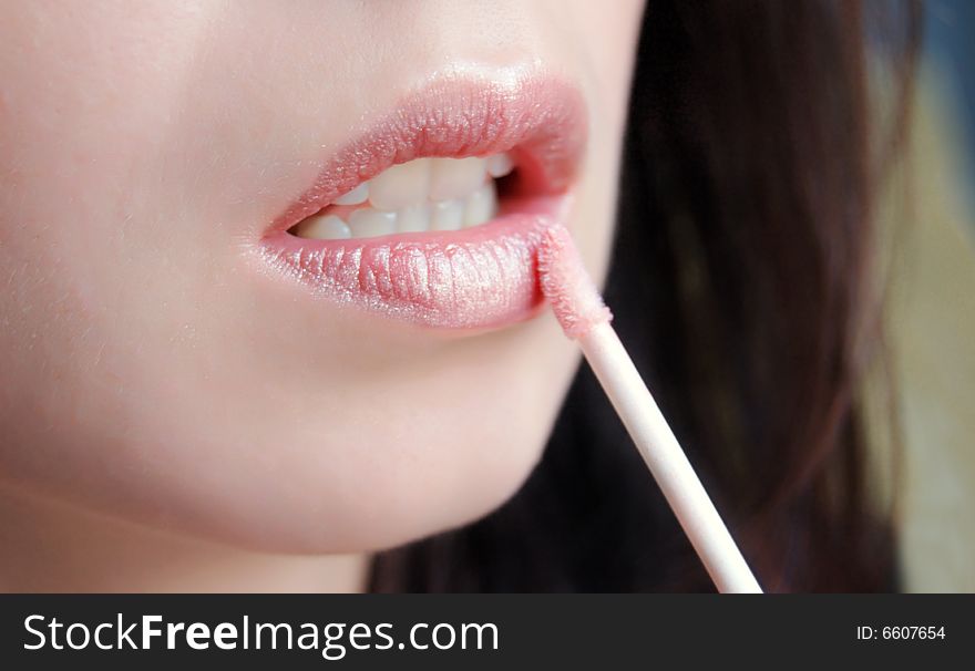 Beautiful woman's lipstick applying