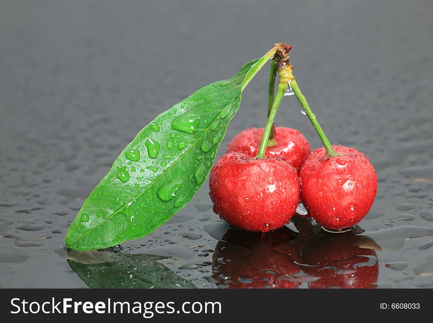 Fresh Cherry with Green Leaf on Wet Glass. Fresh Cherry with Green Leaf on Wet Glass