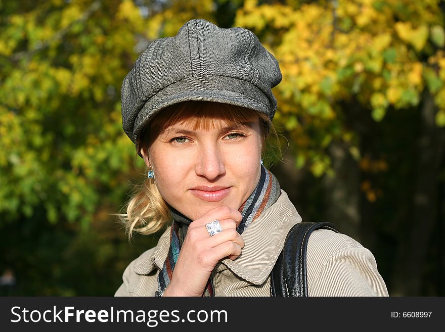 Beautiful blond  young woman in cap in autumn park. Beautiful blond  young woman in cap in autumn park