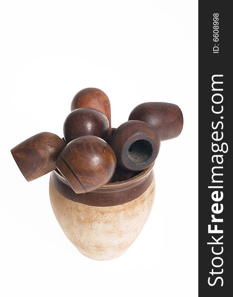 Wooden pipes in clay pot on white background