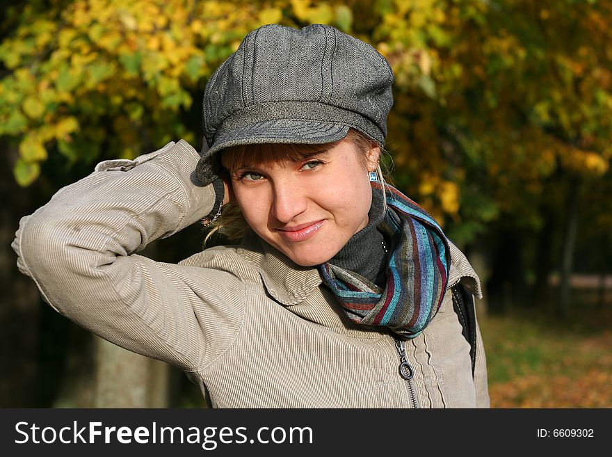 Beautiful blond  young woman in cap in autumn park. Beautiful blond  young woman in cap in autumn park