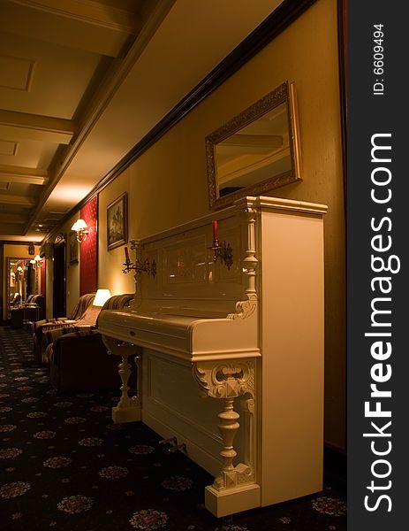 Picture of a lighted lounge area in casino decorated in beautiful vintage style with close-up view of old-fshioned piano. Picture of a lighted lounge area in casino decorated in beautiful vintage style with close-up view of old-fshioned piano