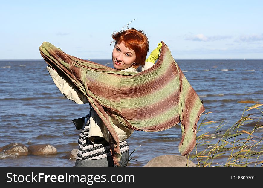 Red haired woman with scarf. Windy day.