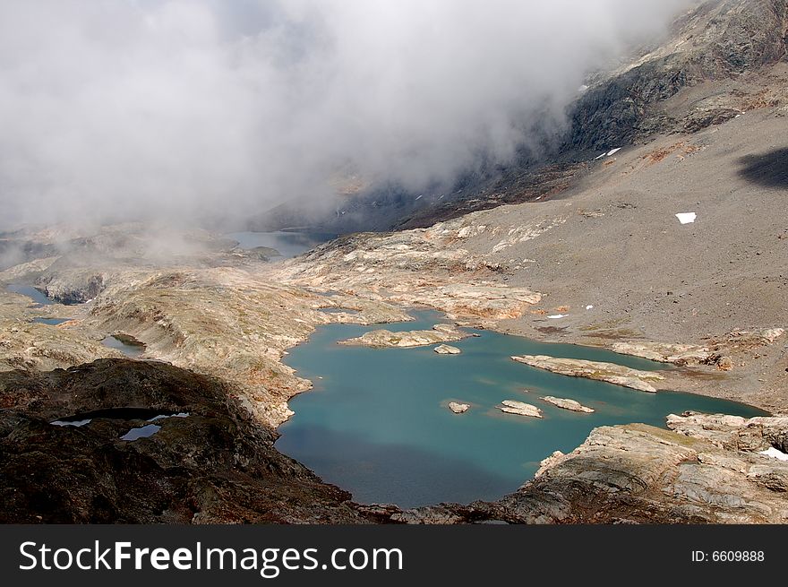 Upcoming fog in mountains on lake 'Lac de la Fare'. Upcoming fog in mountains on lake 'Lac de la Fare'