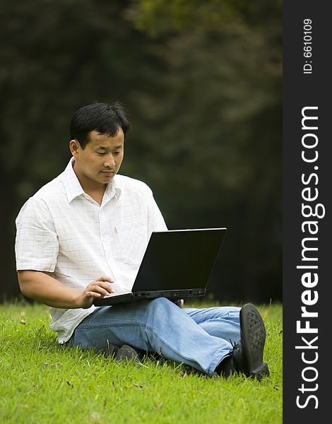 A young man using a laptop outdoors