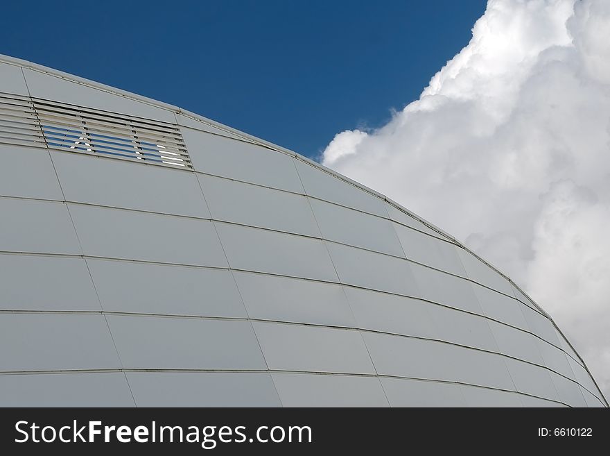 Detail of a curved building against cloudy sky. Detail of a curved building against cloudy sky