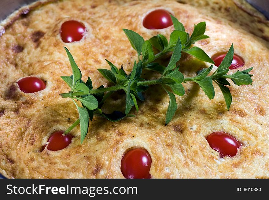 Omelet made with eggs, potato and onion and garnished with cherry tomatoes and herbs. Omelet made with eggs, potato and onion and garnished with cherry tomatoes and herbs