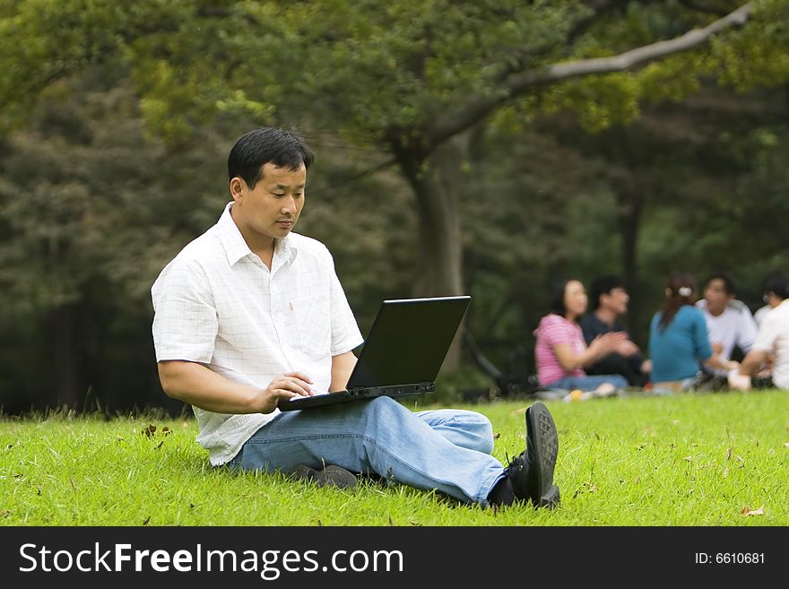 A young man using a laptop outdoors