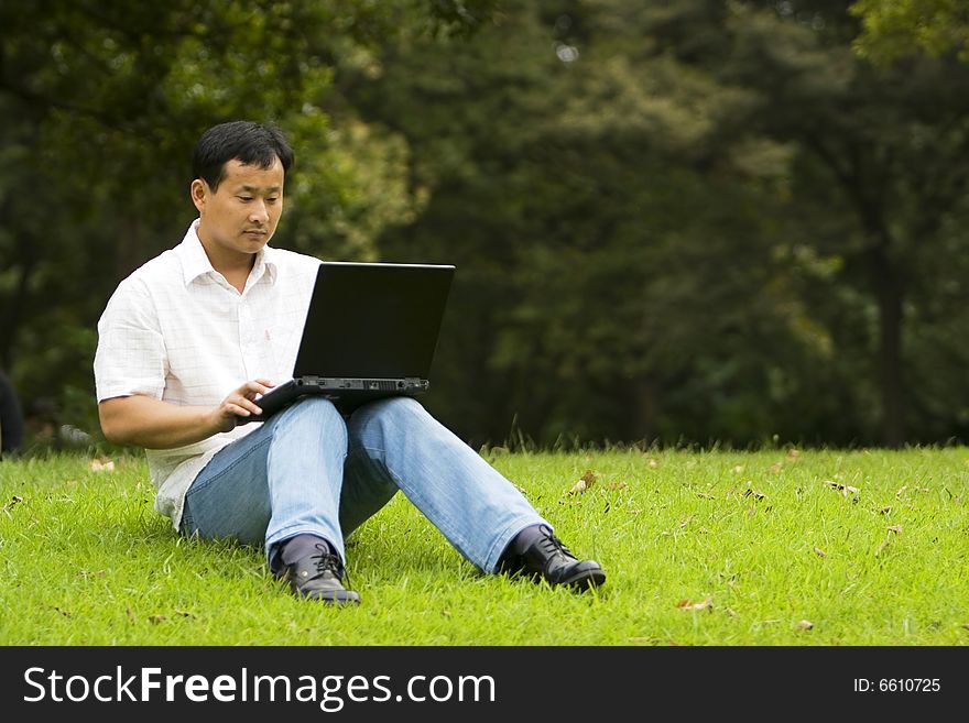 A young man using a laptop outdoors