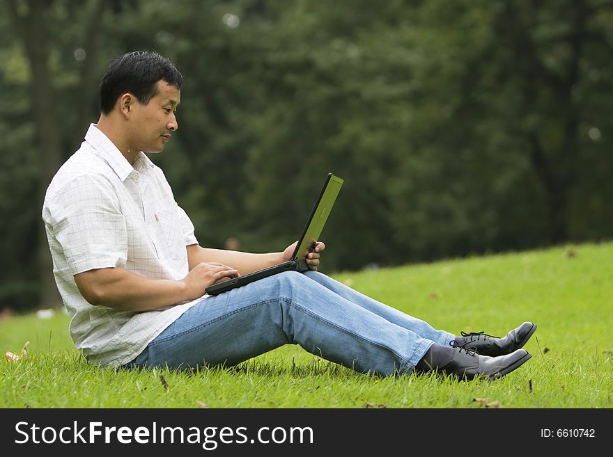 A young man using a laptop outdoors