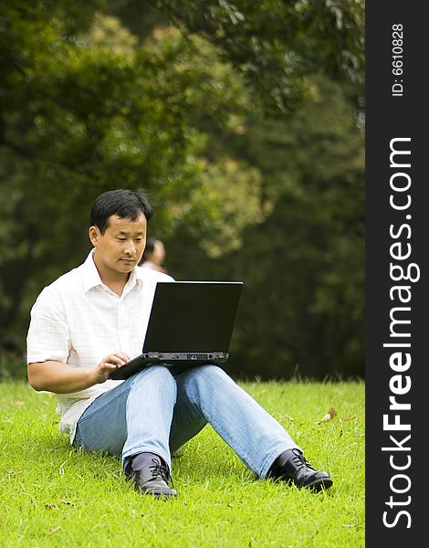 A young man using a laptop outdoors