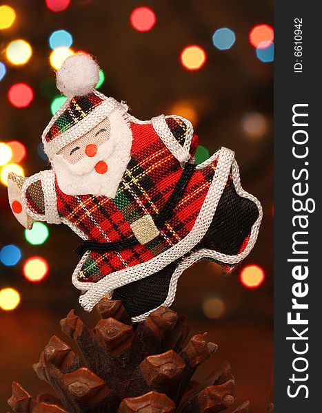 Christmas santa with gift box over a pine cone