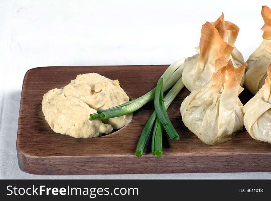 Filo pastries filled with garlic mushrooms and served with humus dip and garnished with spring onion.