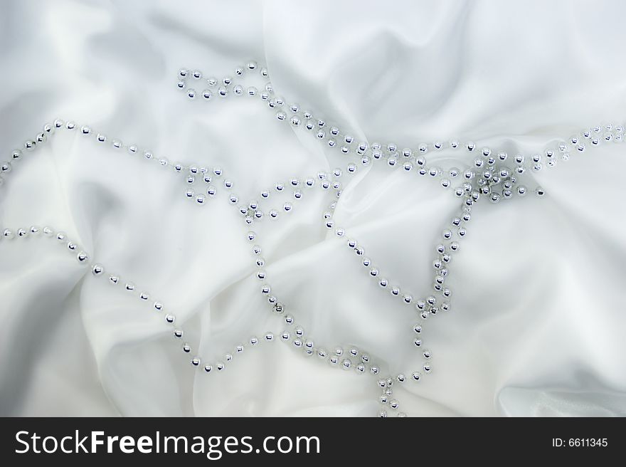 Silver beads on white silk