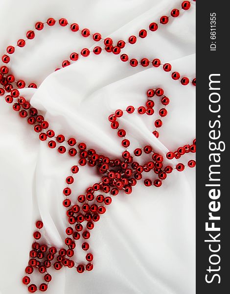 Red beads on white silk