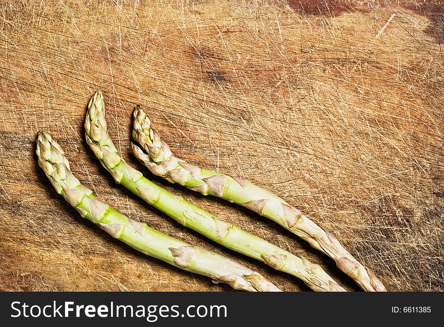 Bunch of asparagus on old wooden table.