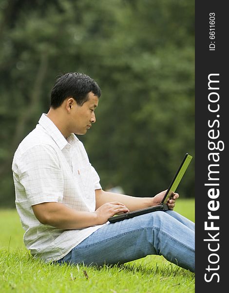 A young man using a laptop outdoors