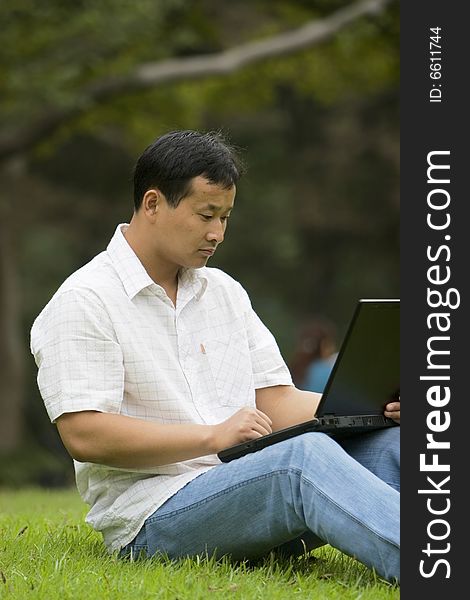 A young man using a laptop outdoors