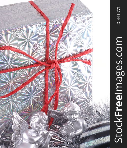 In silver wrapped christmas present with christmas ornaments. In silver wrapped christmas present with christmas ornaments.