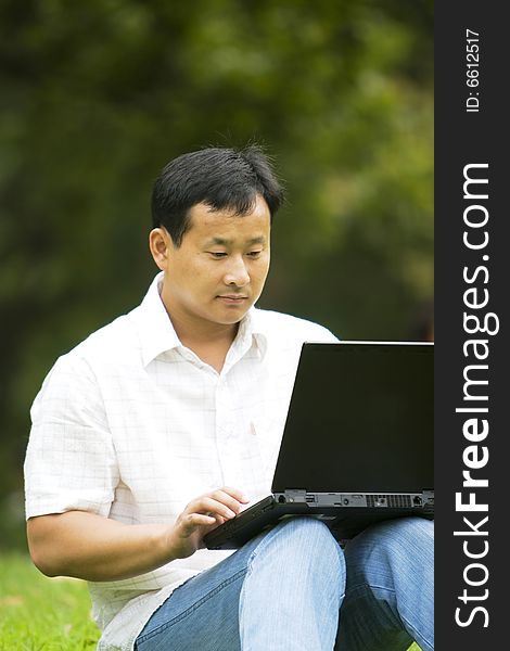 A young man using a laptop outdoors