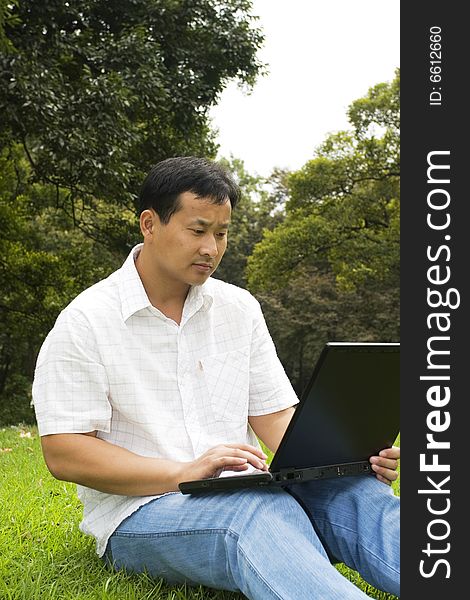 A young man using a laptop outdoors