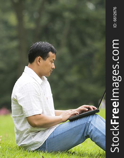 A young man using a laptop outdoors