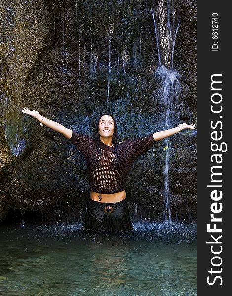 Sensual woman under waterfall