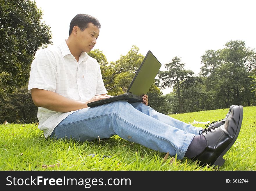 A young man using a laptop outdoors