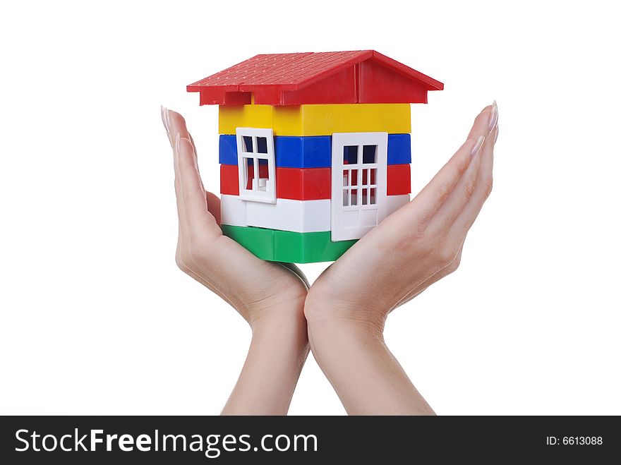 Toy colour plastic house with red roof in palms of young woman. Toy colour plastic house with red roof in palms of young woman